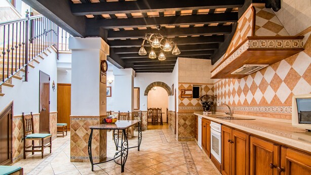 Una cocina amplia con comedor, una escalera y vistas al exterior.