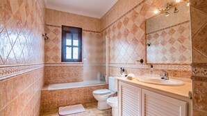 Un baño con bañera, inodoro y lavamanos.
