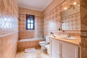 Een badkamer met een bad, toilet en wastafel.