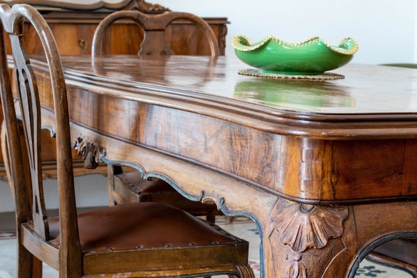 A wooden dining table with a green bowl on it.