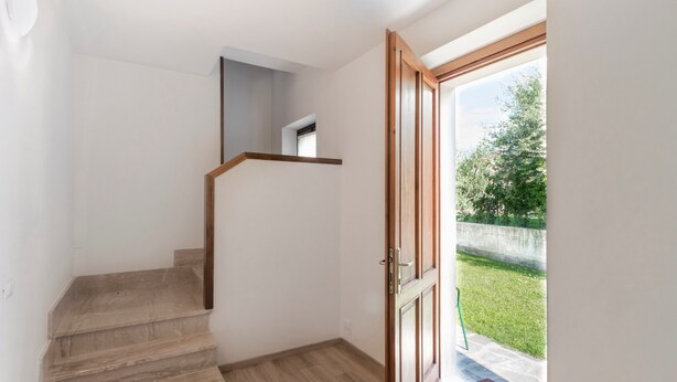 A staircase with wooden steps leading to a landing, a door leading outside, and a small window above the landing. - Holiday Apartment "Bella Cora" With Garden and Private Rooftop Terrace (LAZISE)