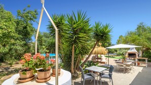 An outdoor patio area with a table and chairs, a grill, and potted plants. - Can Torres. Your charming villa in the heart of Mallorca. (Pòrtol)
