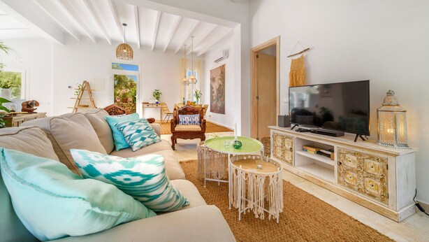 A living room with a sofa, TV, and decorative items. - Can Torres. Your charming villa in the heart of Mallorca. (Pòrtol)