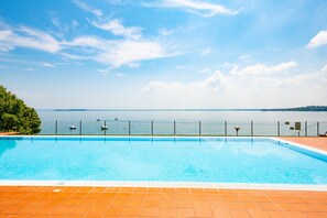 A swimming pool with a view of a body of water and distant land.