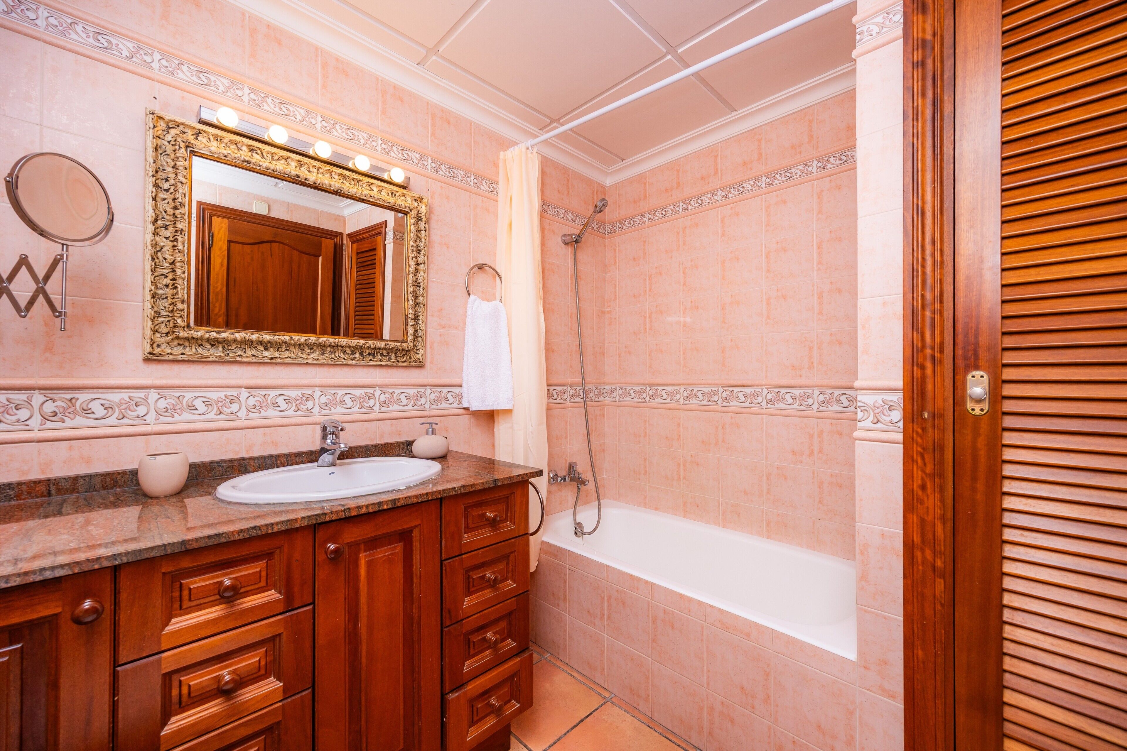Une salle de bain comprenant un meuble-lavabo, un miroir, un évier, une douche et une baignoire.