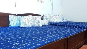 A bed with a blue bedspread and pillows featuring a cityscape design. - I Like B&B (Jinsha)