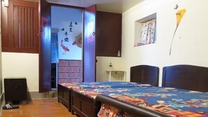 A room with a large bed, a small desk, a brick-patterned floor, and a wall with a butterfly decoration. - I Like B&B (Jinsha)