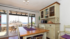 Un comedor con una mesa de madera, sillas y un aparador con puertas de cristal.