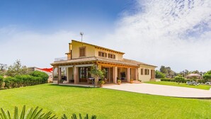 Une maison à deux étages dotée d’un patio couvert, d’une pelouse bien entretenue et d’un ciel dégagé.
