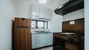 Una cocina equipada con refrigerador, estufa y alacenas.