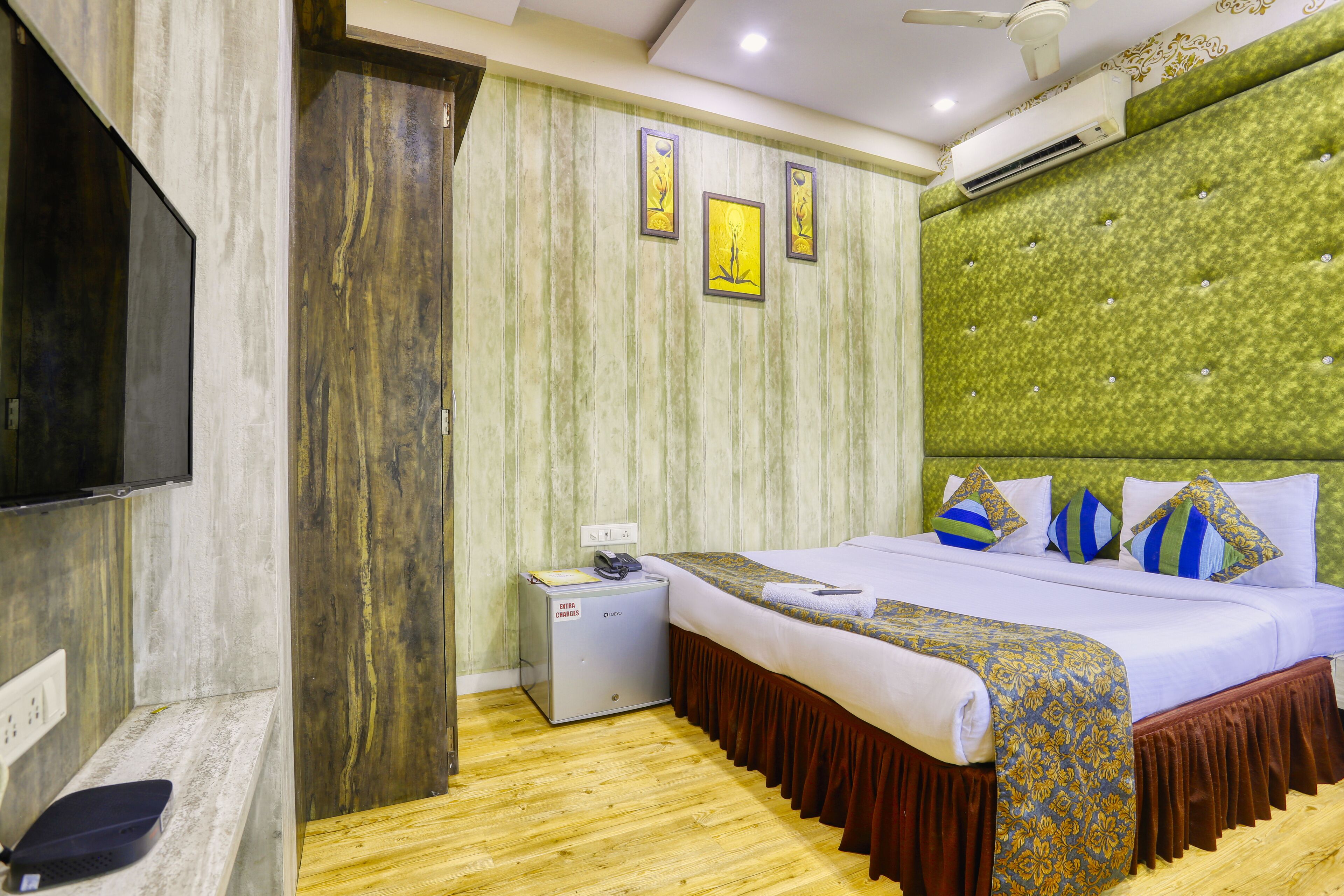 A hotel room with a bed, a television, a desk, and a wardrobe.