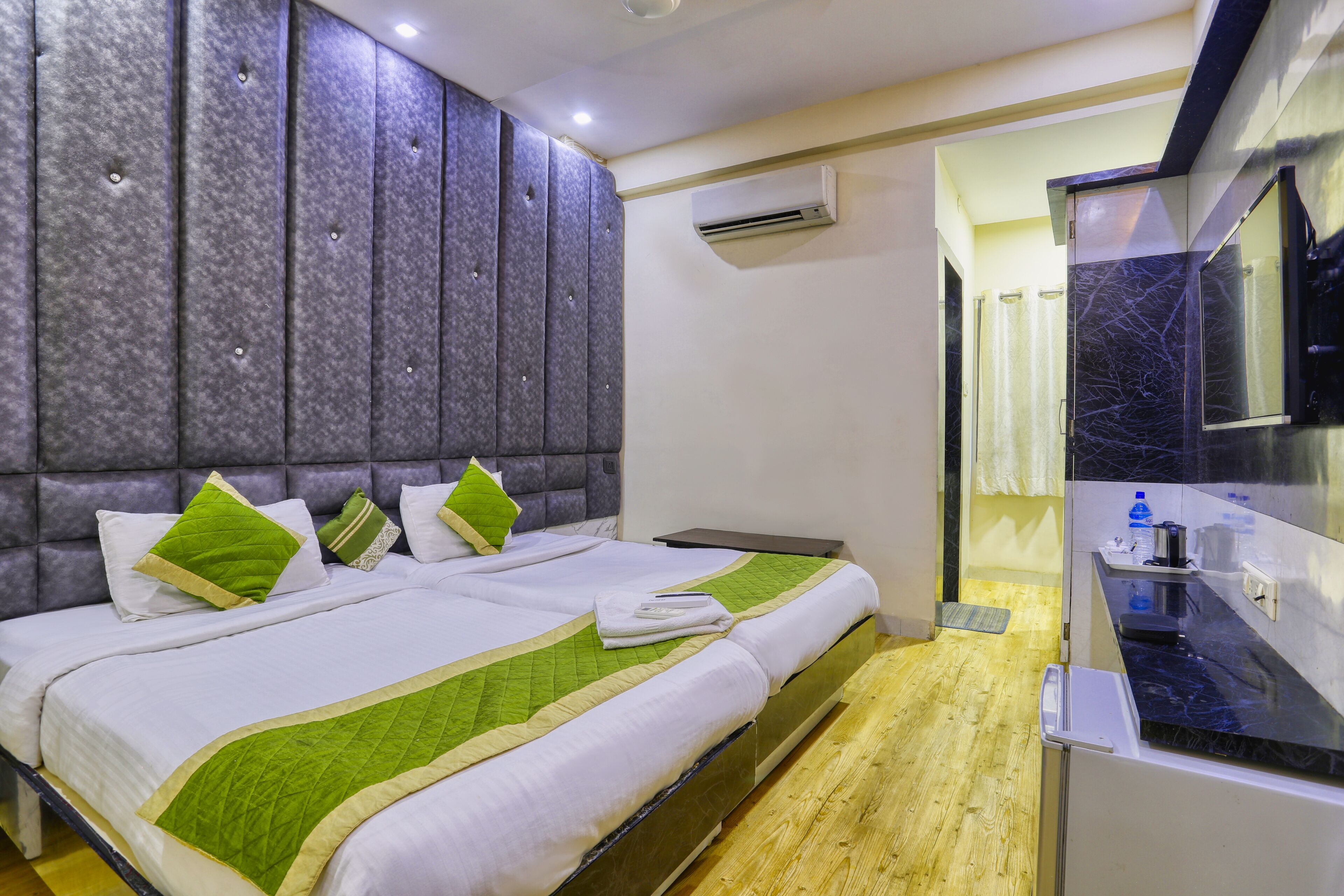 Una habitación de hotel con una cama, una kitchenette pequeña y un equipo de aire acondicionado.