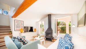 Una sala de estar moderna con chimenea, un sofá, un televisor y una escalera.