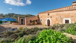 A rustic building with a tiled roof, a door, and a window. - Charming Holiday Home Can Bonjesus with Mountain View, Wi-Fi, Garden & Terrace; Parking Available, Pets Allowed (Felanitx)