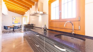 Una cucina moderna con un'ampia finestra, forno integrato e zona pranzo con sedie.