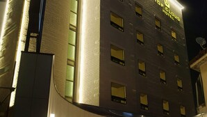 A hotel with a modern facade, multiple windows, and a well-lit entrance. - Top Cloud Hotel Cheonan (Cheonan)