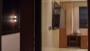 A hotel room with a desk, chair, and a large mirror. - Top Cloud Hotel Cheonan (Cheonan)