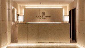 A reception desk at the Top Cloud Hotel with a modern design, a logo, and a clean, well-lit interior. - Top Cloud Hotel Cheonan (Cheonan)