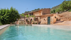 Une piscine avec des bâtiments en pierre en arrière-plan.