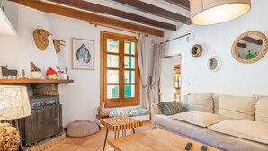 Un salon chaleureux avec une cheminée, un canapé et une table en bois.