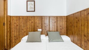 A double bed with two pillows, a wooden headboard, and a framed picture on the wall. - Holiday Apartment "Estudio Lila" with Wi-Fi and Air Conditioning (Conil de la frontera)