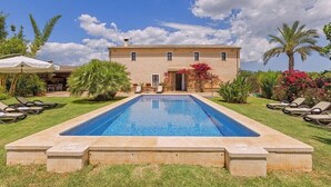 Une piscine avec une maison en arrière-plan.
