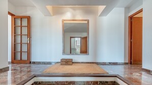 A hallway with a wooden door, a mirror, and a small rug on a tiled floor. - Modern Apartment with Balconies & Wi-Fi; Pets Allowed, Parking Available (Felanitx)