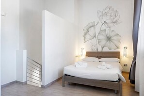 Un dormitorio con una cama, una escalera y un mural en la pared.