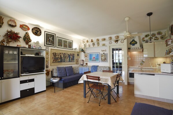 A compact living space with a kitchenette, dining area, and a sofa.