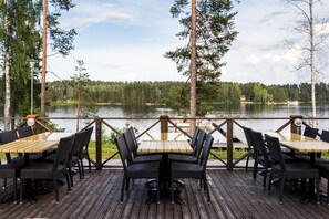 Une terrasse en bois avec une table et des chaises donnant sur un lac.