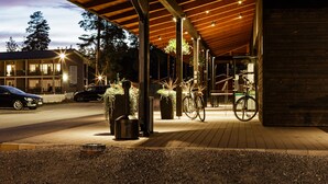 A covered outdoor area with a wooden roof, potted plants, and bicycles. - Punkaharju Resort (Savonlinna)