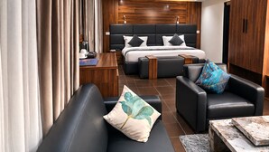 Una habitación de hotel moderna con una cama grande, un sofá, una mesita de centro y un escritorio.