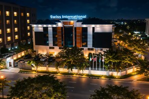 Een modern hotel met een opvallend bord waarop 'Swiss International The Vistana-LeKki' staat.