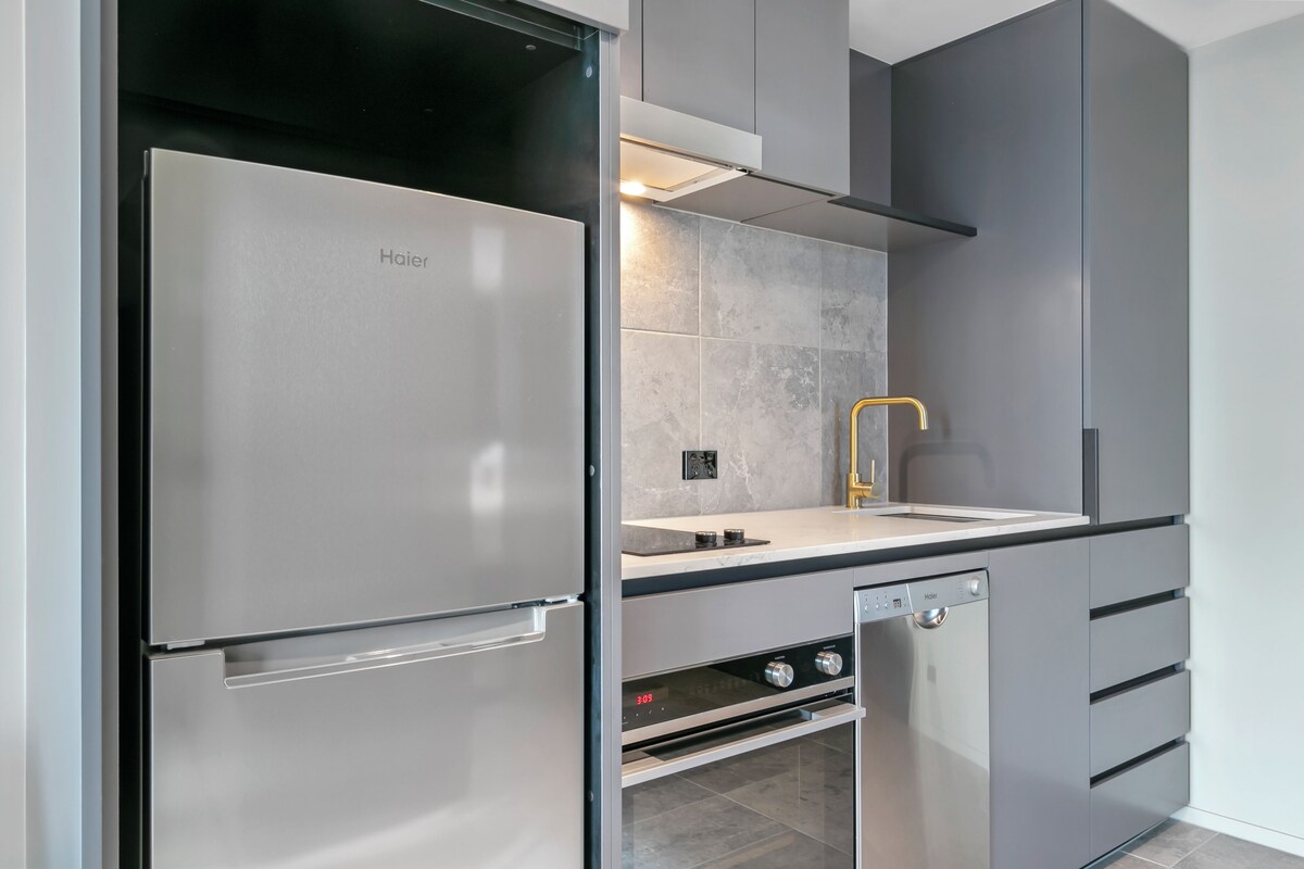 A modern kitchen with a Haier refrigerator, a built-in oven, and a dishwasher.