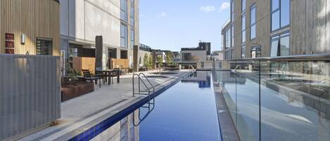 Ein modernes Gebäude mit Schwimmbad, Außenbereich und blauem Himmel.
