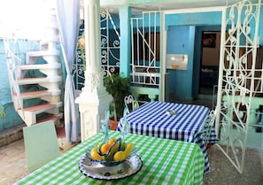 A patio area with a checkered tablecloth, a fruit bowl, and a staircase. - Loucel Trinidad (Trinidad)