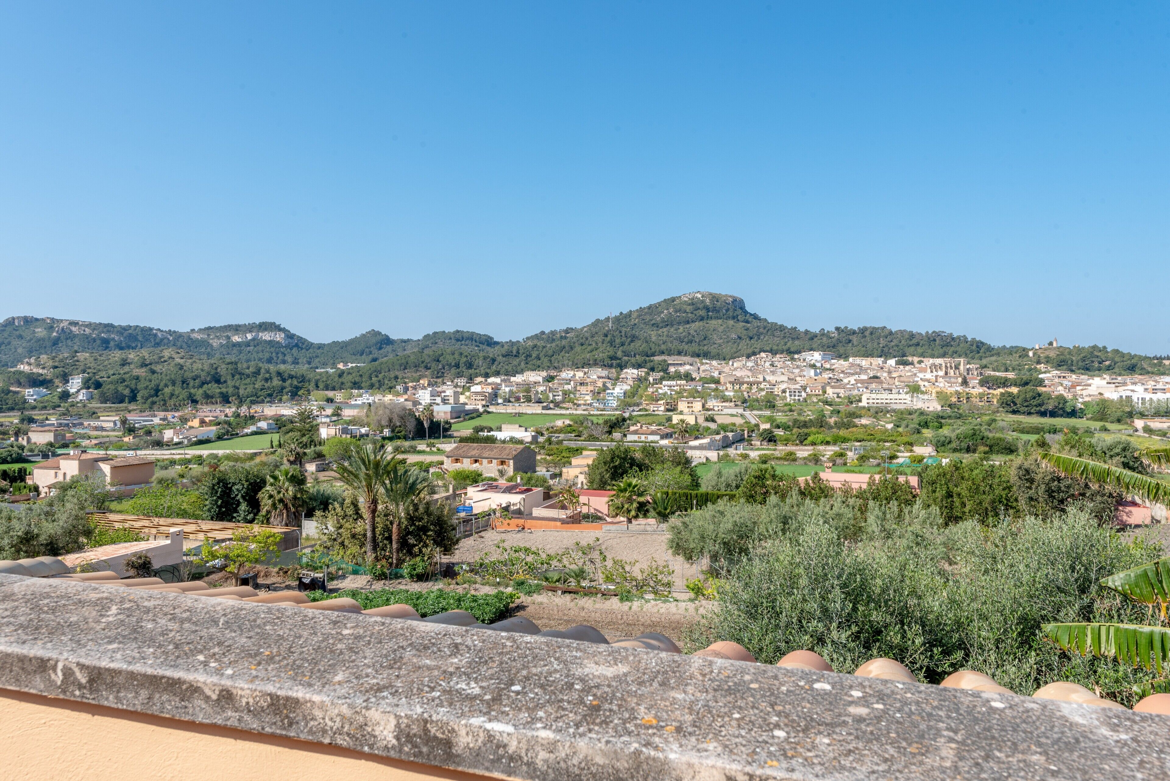 Une ville côtière offrant une vue sur la mer et les collines qui se dessinent à l’horizon.