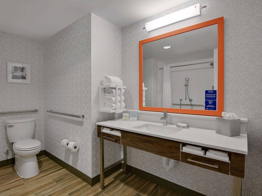 Un baño moderno con inodoro, lavabo y espejo.