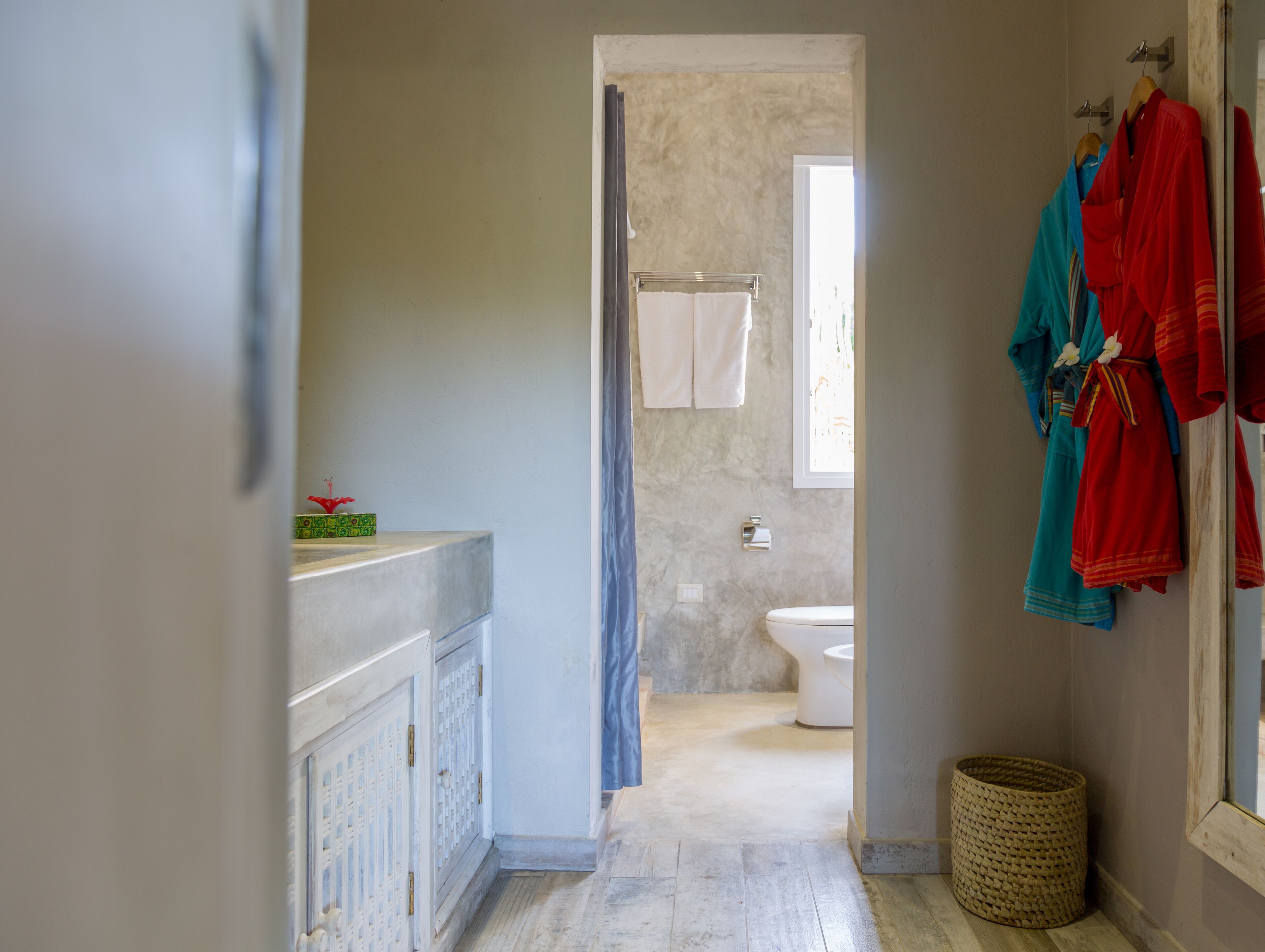 A bathroom with a toilet, a shower curtain, and a towel rack.