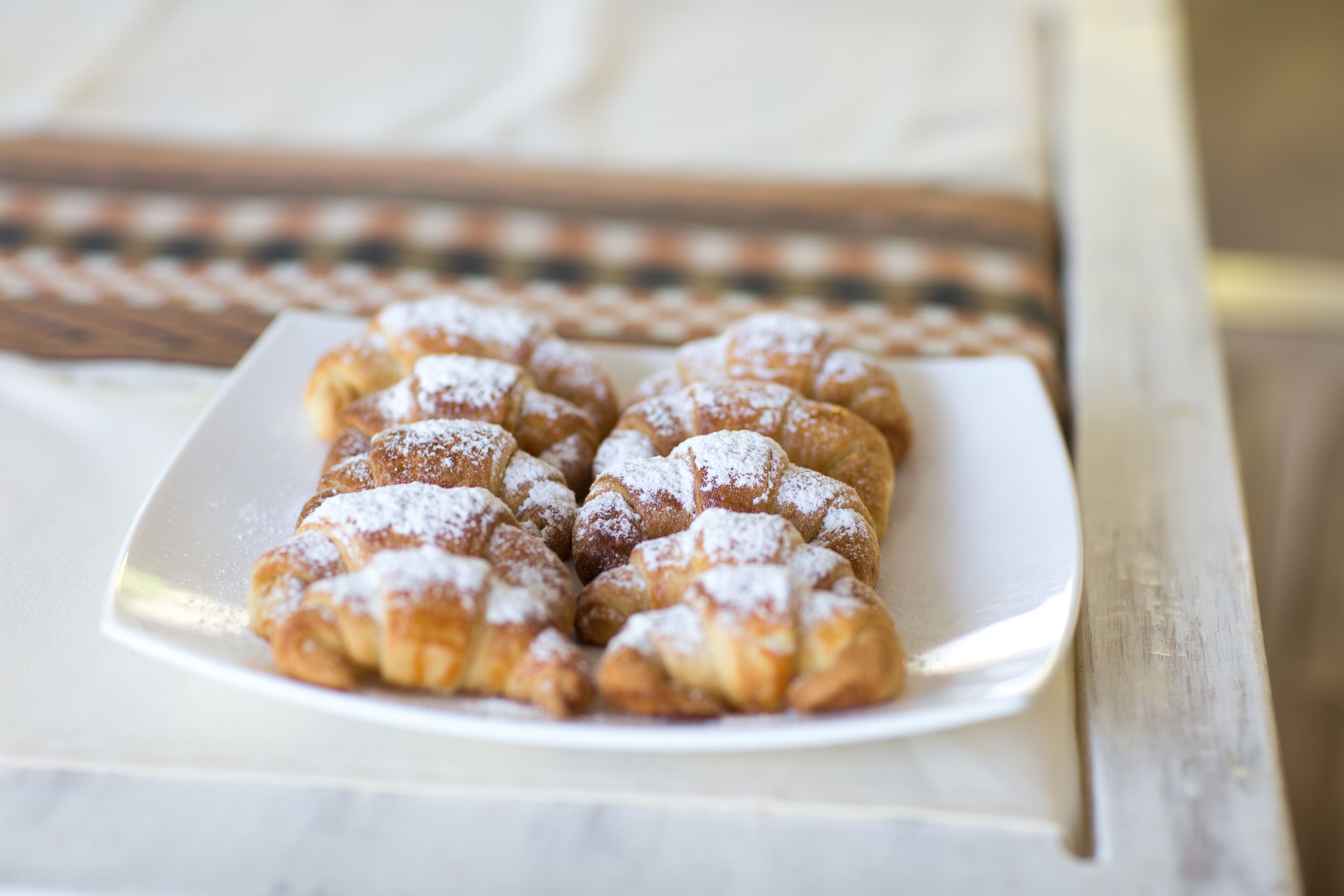 A plate of pastries dusted with powdered sugar.
