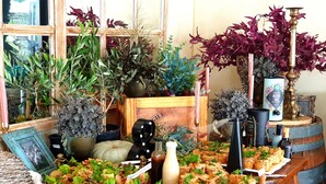 A buffet table with various dishes, a decorative vase, and potted plants. - Maison de Leo Luxury Guesthouse (Pretoria)