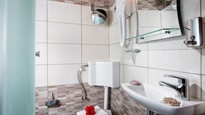 A modern bathroom with a toilet, sink, and a mirror. - Charming Studio Near the Beach (Hersonissos)