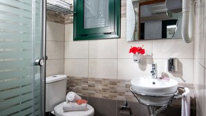 A bathroom with a toilet, sink, and glass shower enclosure. - Cozy Studio in Hersonissos Center (Hersonissos)