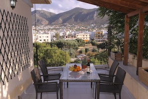 Ein Balkon mit Tisch, Stühlen und einer Obstschale.