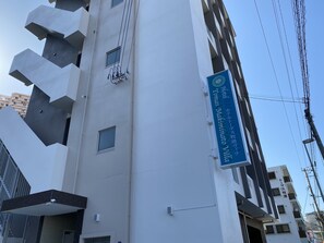 Un edificio moderno con un cartel que indica Hotel Tomas Makimachi Villa.