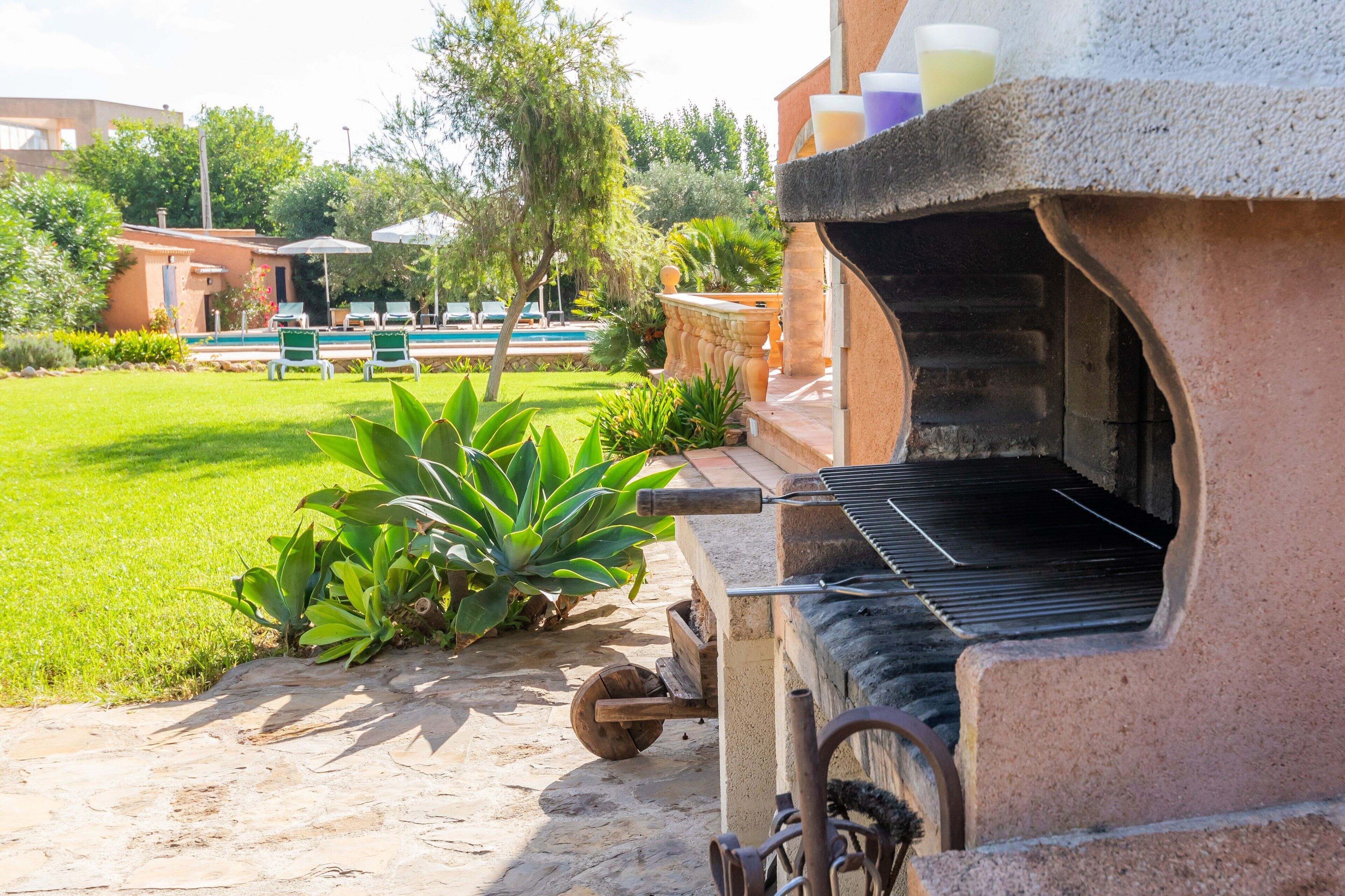 Barbecuegrill, buitenzitplaatsen en een zwembad in een resort omgeving.