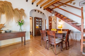 Un comedor con muebles de madera, una escalera y una decoración rústica.