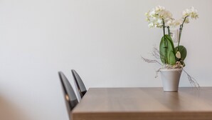 Een eettafel met stoelen, een potorkidee en een stopcontact.