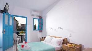 A bedroom with a bed, bedside table, and a desk with a chair. - Lovely Studio in the City Center (Hersonissos)