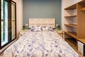 Une chambre à coucher avec un lit, des tables de chevet, une commode et une fenêtre.